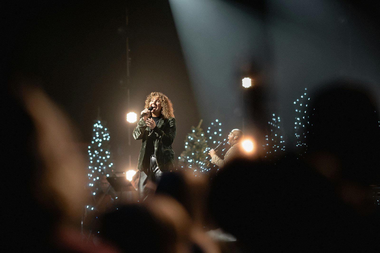 a woman standing on top of a stage holding a microphone