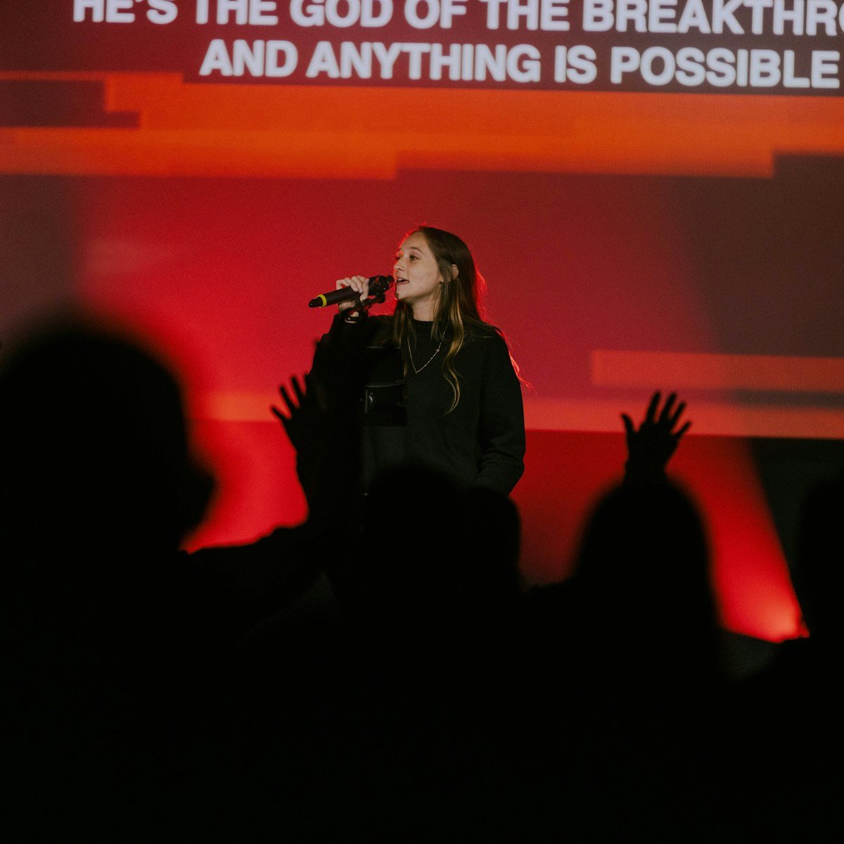 a woman standing in front of a microphone on a stage